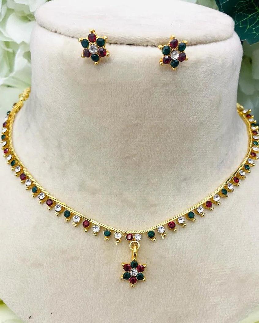 Jewelry set with necklace and earrings on a white stand with floral background