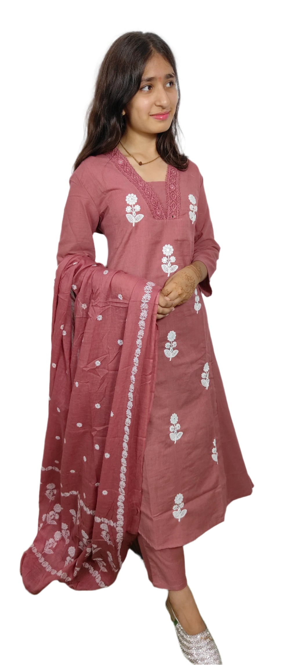 Woman wearing a pink traditional outfit with white floral patterns on a white background